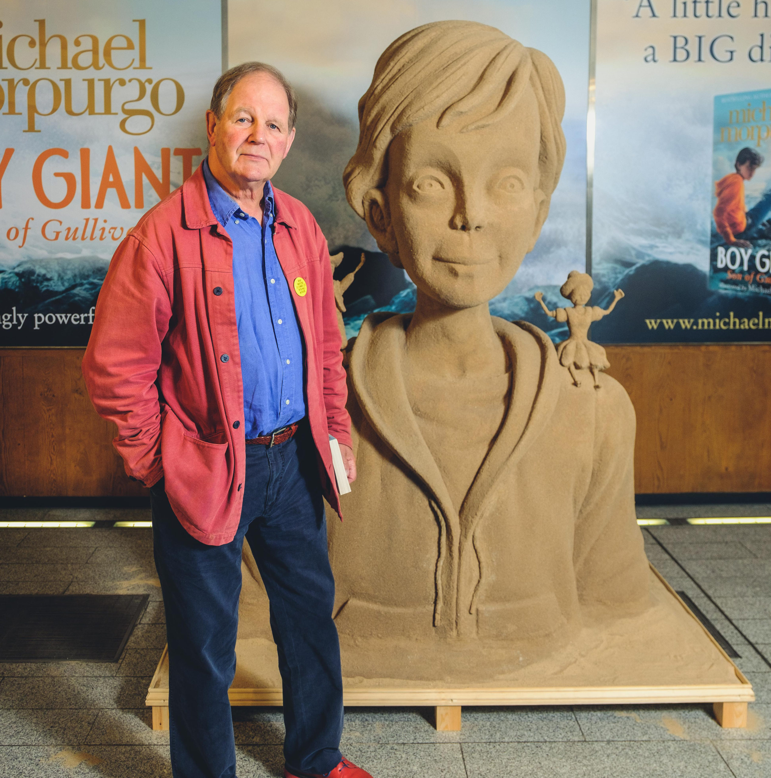Michael Morpurgo standing next to Boy Giant statue